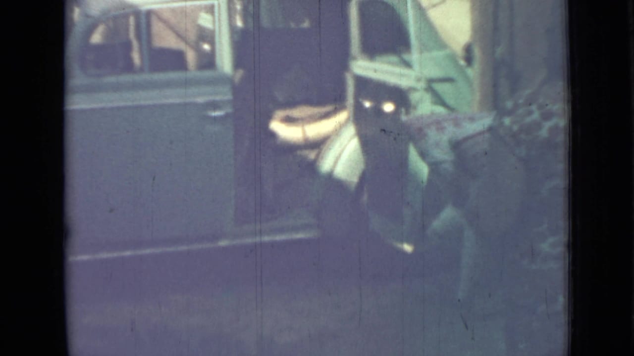 A person in a patterned dress approaches the open rear door of a blue van in the supplied 1967 Saint Petersburg footage.