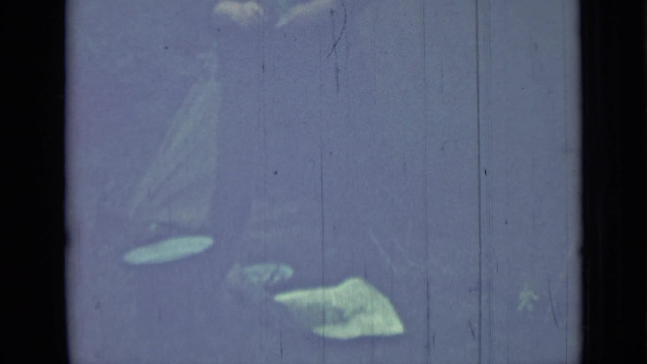 Partial hand and pale tent fabric visible through a faded scratched film frame.