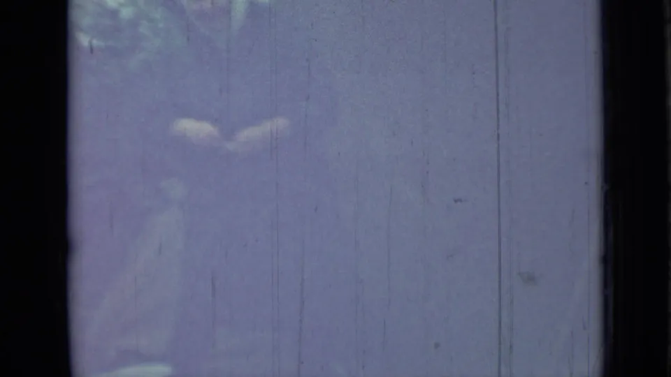 A partially visible person appears near campsite fabric in the 1967 Saint Petersburg home-movie footage, obscured by exposure and film aging.