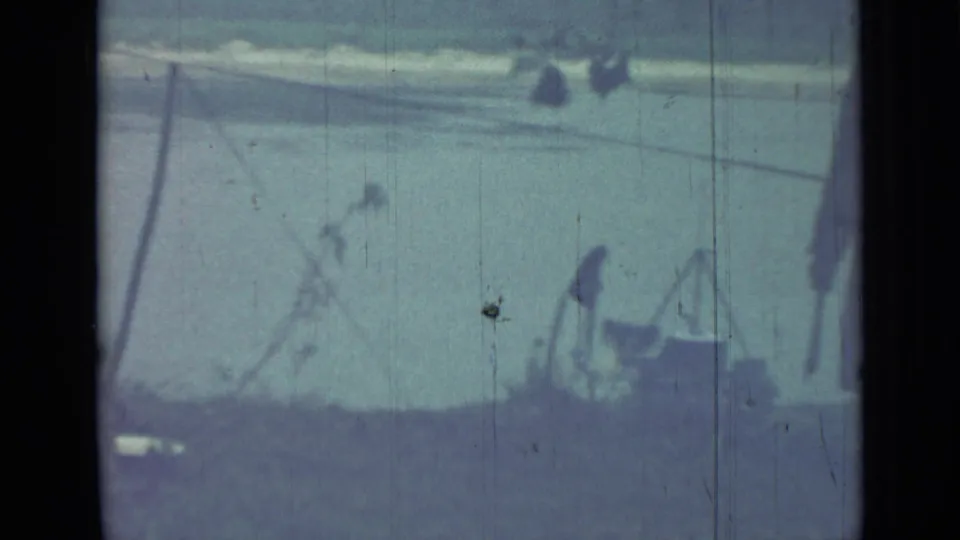 1967 Saint Petersburg 8mm frame showing a grassy outdoor area near water with trees and small equipment in soft blue tint.