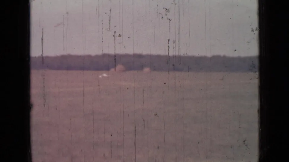 1967 8mm home-movie view near Saint Petersburg showing a muted open field, low horizon, and dark window-like framing.