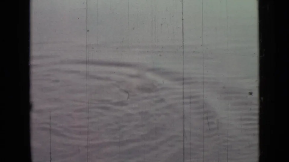1967 8mm home-movie still showing fading ripple lines on open water with muted color and frame wear.