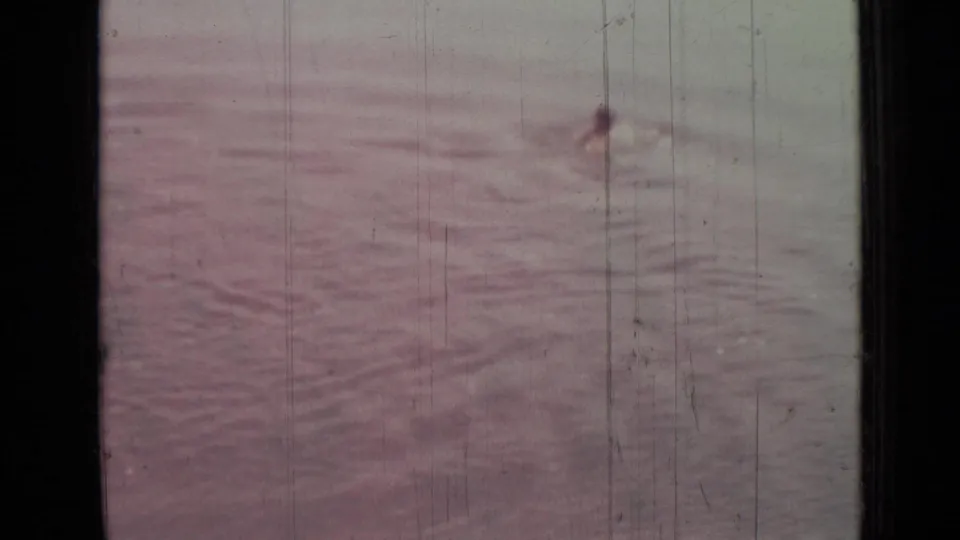1967 Saint Petersburg 8mm frame showing pink-gray water reflections with vertical scratches and soft exposure variation.