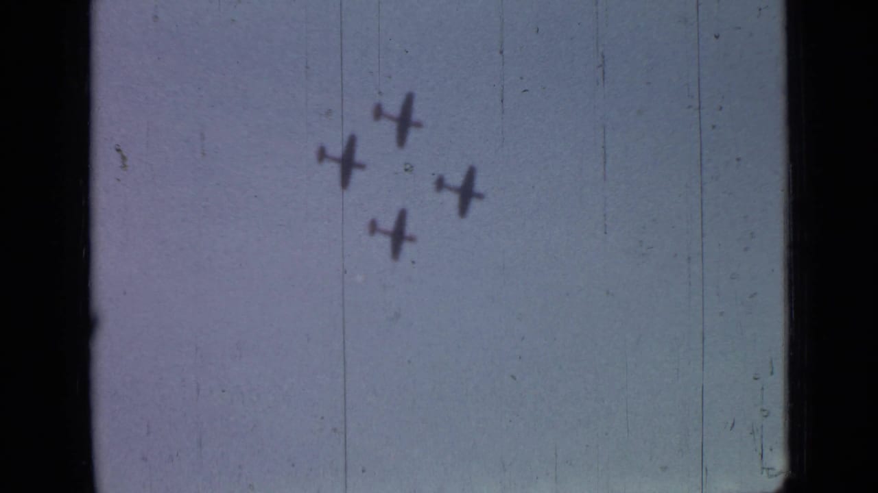 Four small aircraft fly in formation across a pale sky.