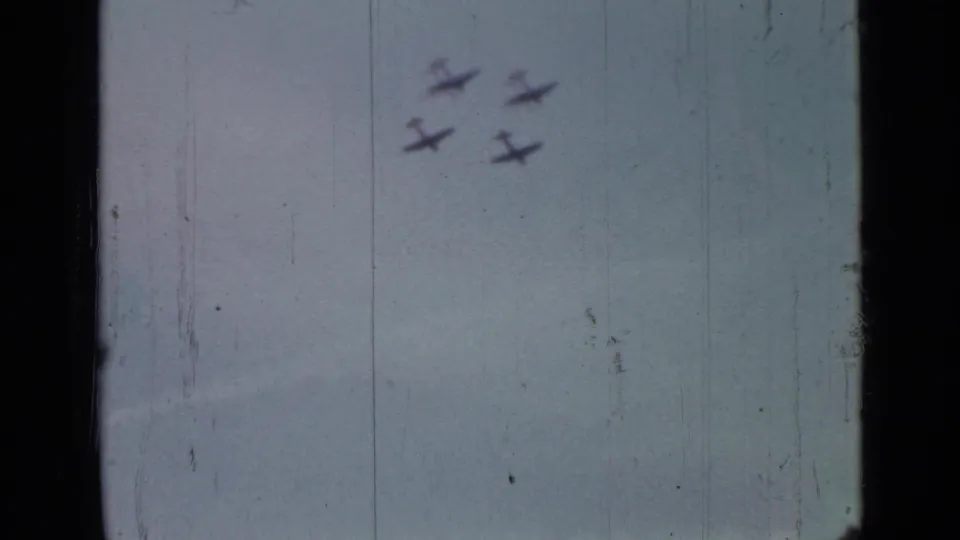 Four small aircraft move through a hazy blue-gray sky in archival 8mm footage from 1967 Saint Petersburg.
