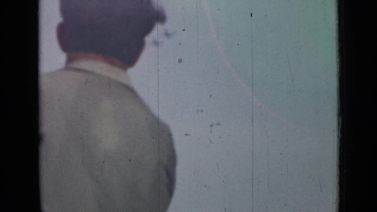 Man seen from behind at the left edge against a pale sky.