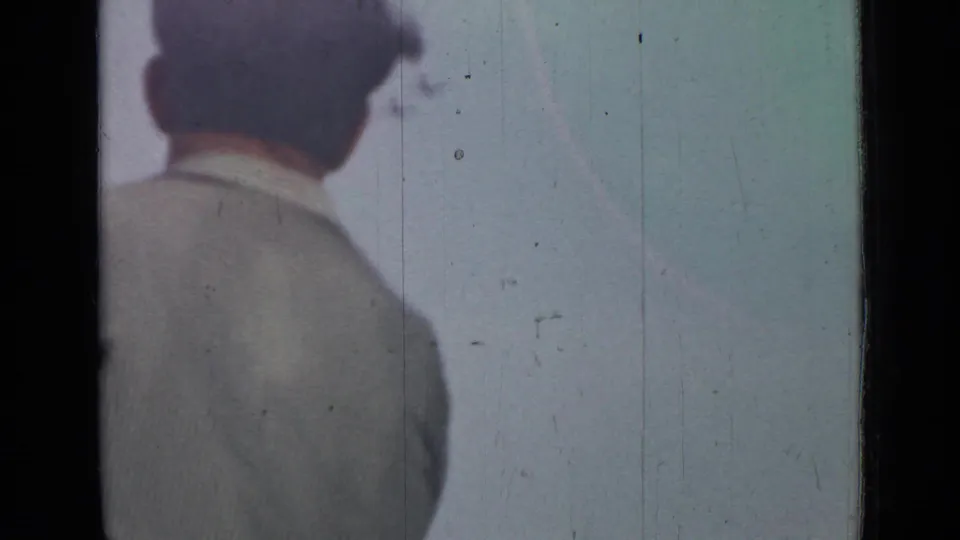 In supplied 1967 Saint Petersburg 8mm footage, a man in a light shirt is seen from behind near the left edge under a washed sky.