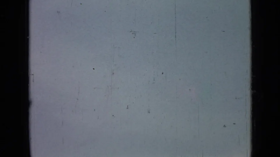 The 8mm frame shows a bright, overexposed sky with dark gate edges and visible scratches from the physical film scan.