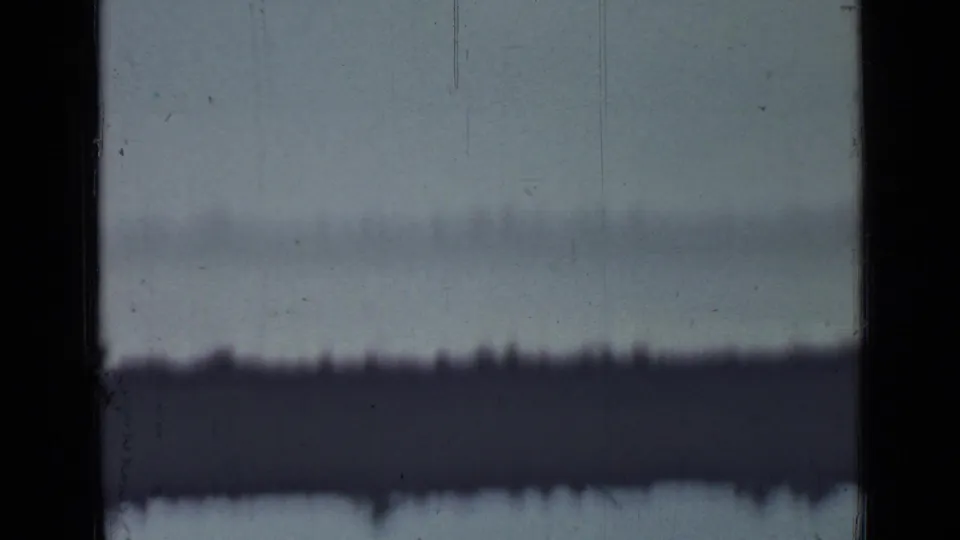 1967 Saint Petersburg metadata frame showing a pale overexposed sky, black 8mm frame borders, surface scratches, and a distant dark horizon-like band.