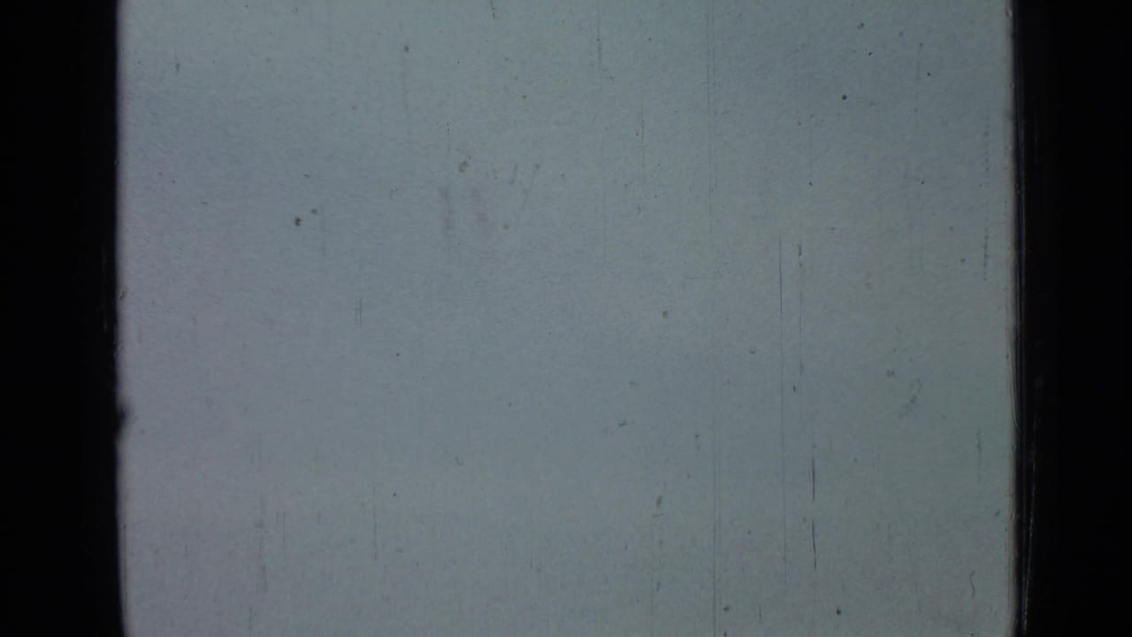 Overexposed pale sky from the supplied 1967 Saint Petersburg clip, with black gate edges, faint scratches, dust, and no identifiable subject.