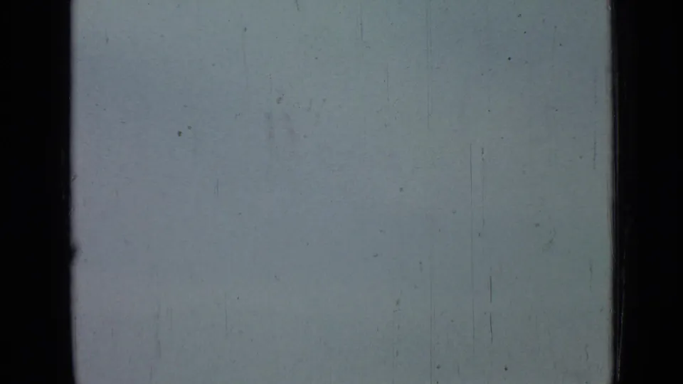 Overexposed pale sky from the supplied 1967 Saint Petersburg clip, with black gate edges, faint scratches, dust, and no identifiable subject.