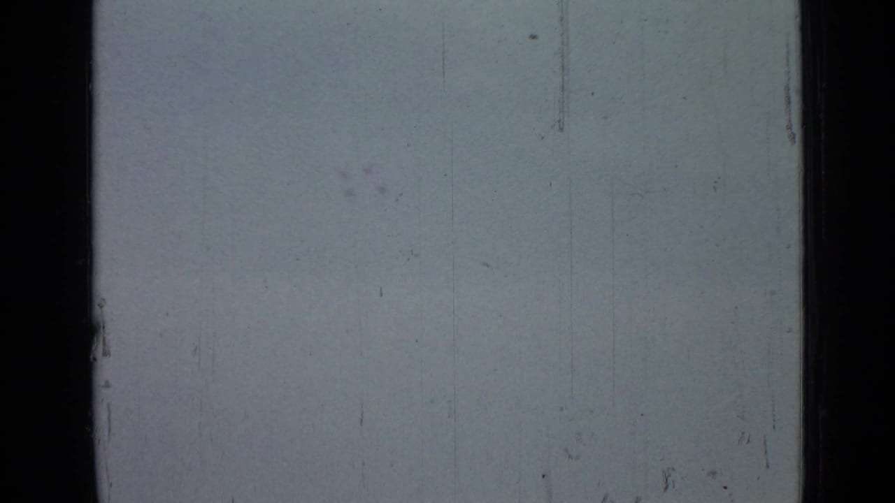 Washed-out sky area in the 1967 Saint Petersburg metadata clip, showing 8mm frame edges, scratches, dust marks, and uneven exposure.