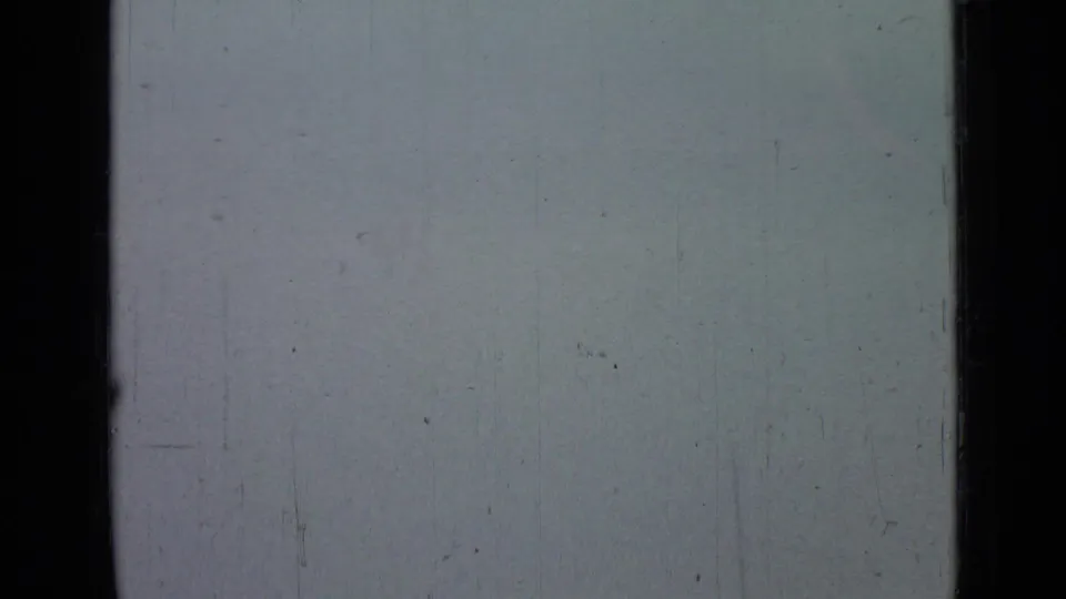 Pale gray-blue sky from the supplied 1967 Saint Petersburg home-movie metadata, bordered by dark film edges with visible dust, scratches, and color fading.