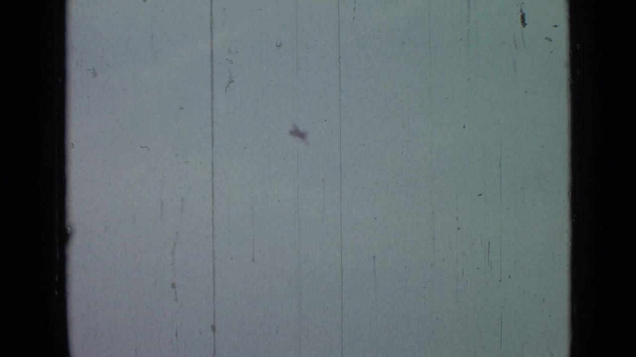 Pale cloudy sky with dark film edge and faint vertical scratches.