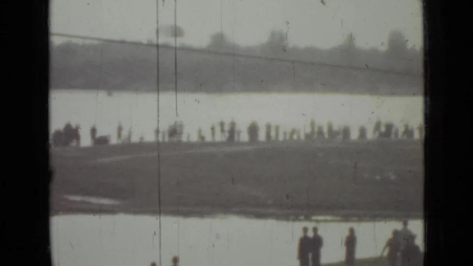 Soft 1967 Saint Petersburg lakeside frame showing a long line of distant spectators and a few closer figures near the bottom edge.