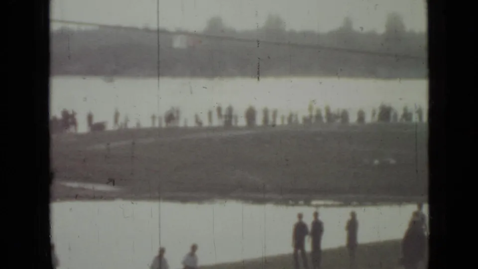 1967 Saint Petersburg home-movie view of a shoreline crowd near a broad waterway, seen through dark film frame edges.