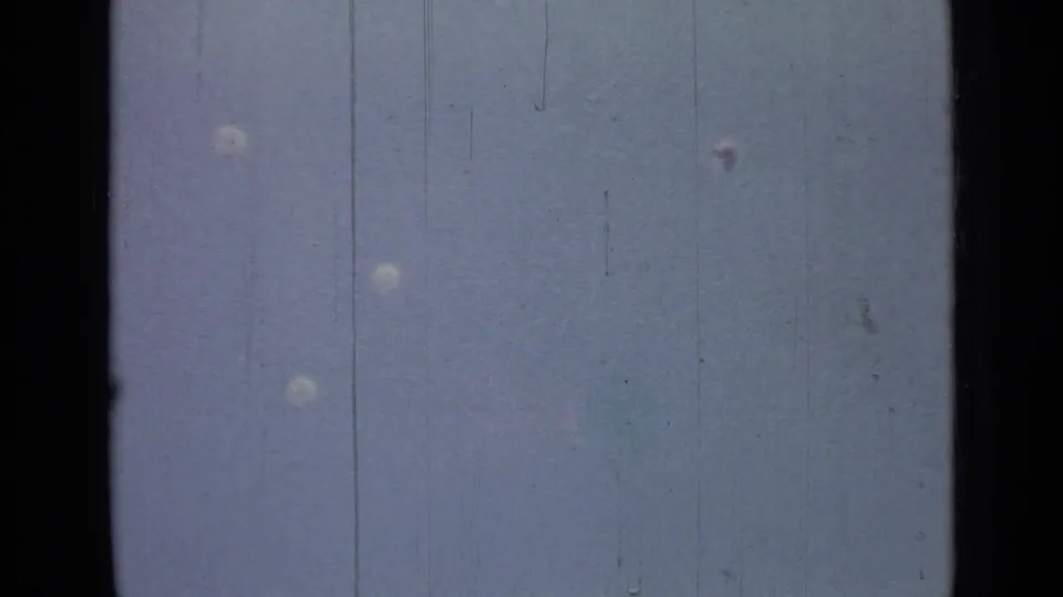 Several parachutes descend through the sky in 1967 8mm footage from the Saint Petersburg lake scene.