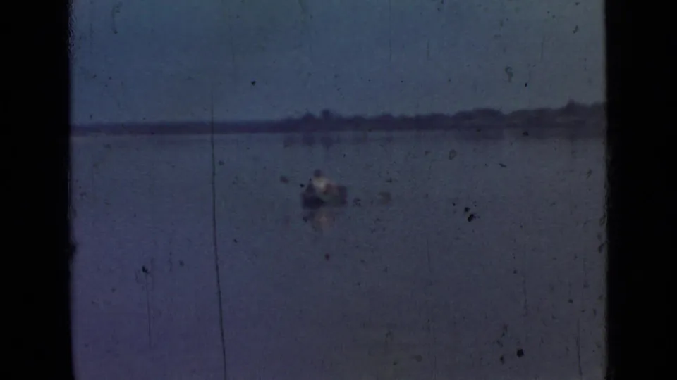 1967 Saint Petersburg lakeside frame with a small rowboat on open water and a low distant shore.