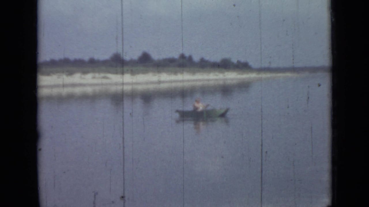 Soft 8mm frame showing a lone rower in a small boat on calm water, with Saint Petersburg location supported by clip metadata.