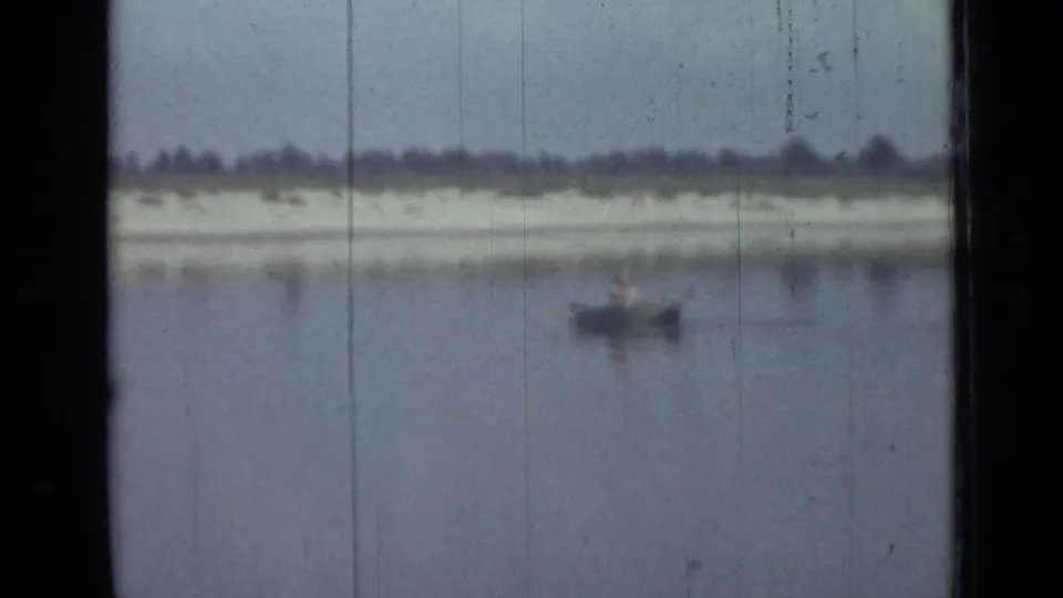 Distant person in a small rowboat crosses calm water in this soft 1967 Saint Petersburg 8mm frame.