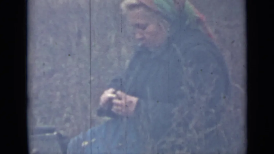 1967 Saint Petersburg 8mm still showing a bundled adult wearing a headscarf in snowy woodland, with the face softly visible.