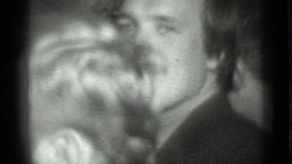 The final frame shows smiling adult men close to the lens, with faces softened by grain and motion in the 1975 Moscow home movie.