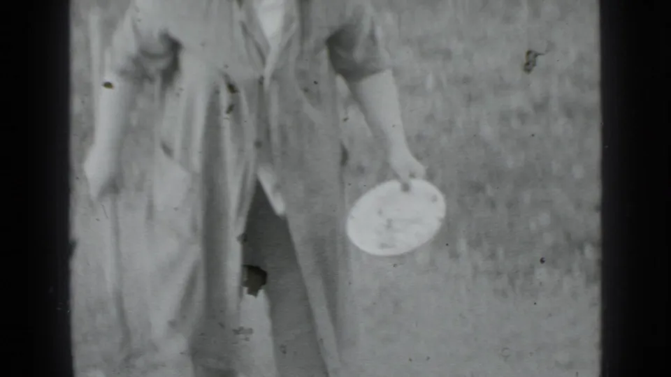 A woman in 1975 Moscow home-movie footage stands outdoors with a hoe and a round container after working the ground.