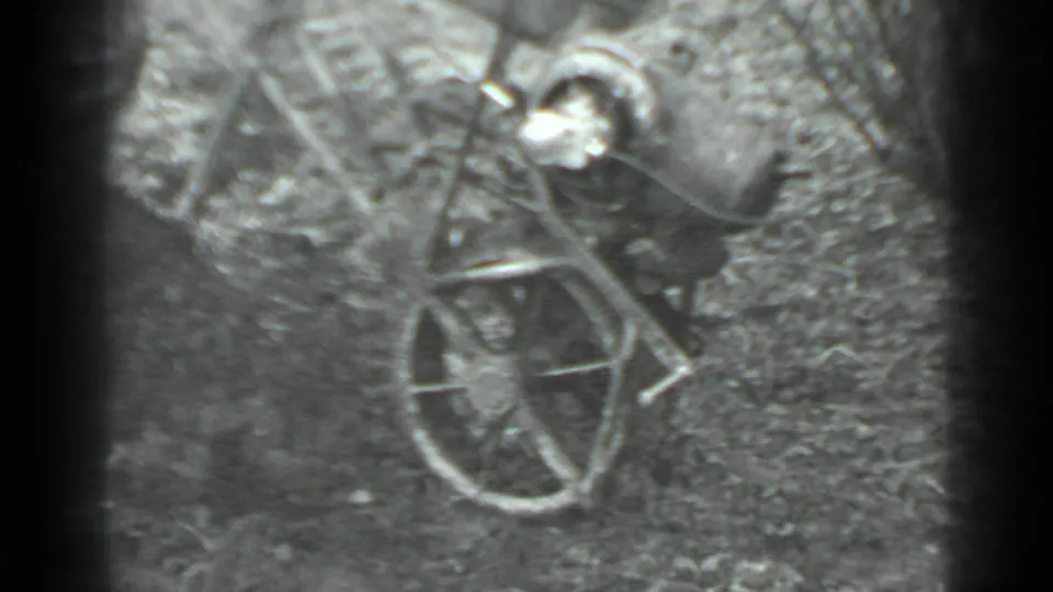 In 1975 Moscow home-movie footage, a man appears with a manual push mower in an uneven grassy yard.