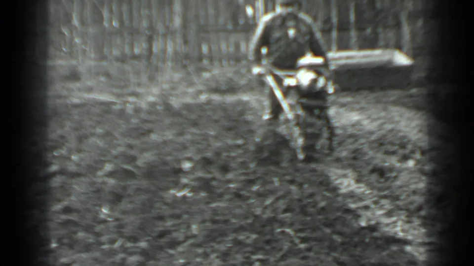 The man remains behind the motorized cutter, moving it through muddy terrain in the Moscow yard or wooded area.