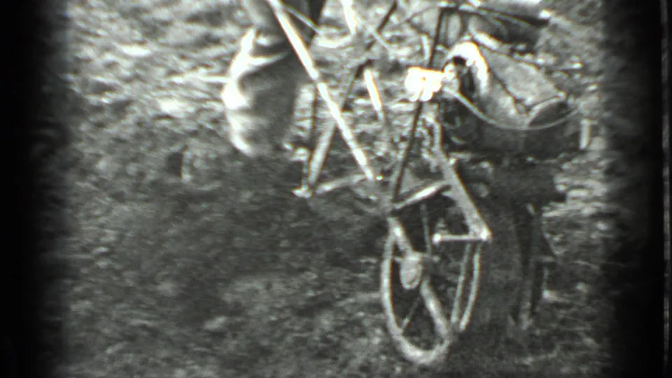 In 1975 Moscow home-movie footage, a man in work clothes guides a small hand tiller through a patch of rough garden soil.