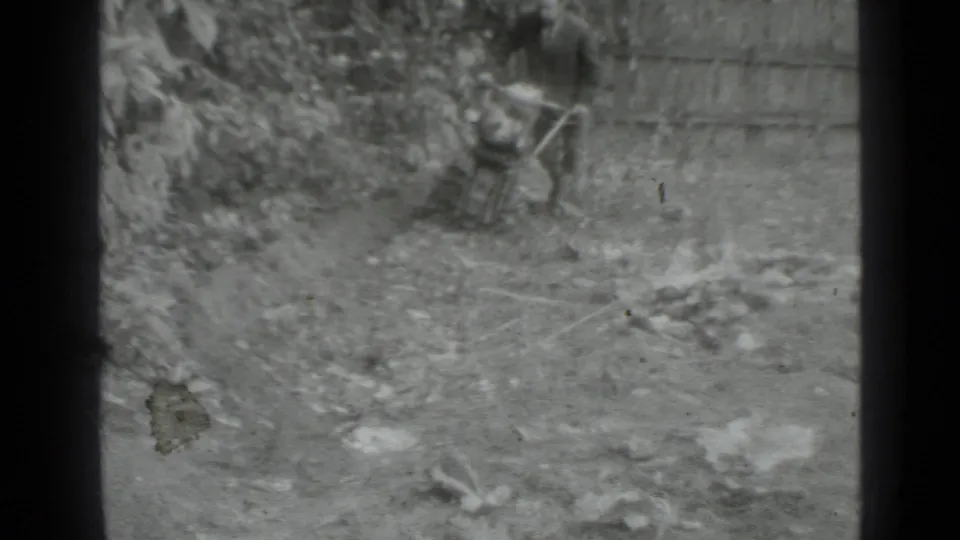 The final frame emphasizes the ground, garden tool, rough soil, and fence line in the 1975 Moscow home-movie scene.