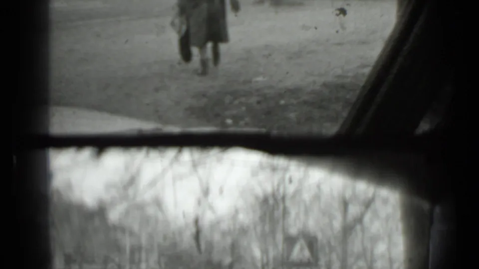 1975 Moscow 8mm frame with the woman's lower body and handbag partly framed by a vehicle window and soft film blur.