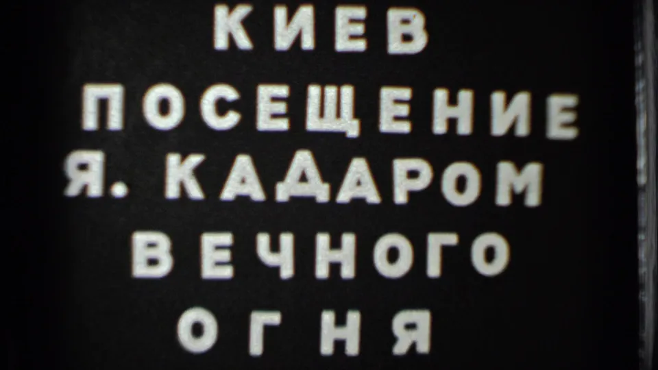 Close 8mm view of the Cyrillic title card, with the Kiev and Eternal Flame wording visible on black.