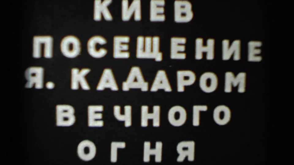Static 1983 8mm title-card frame showing the visit text, with scratches and dust near the lower edge.
