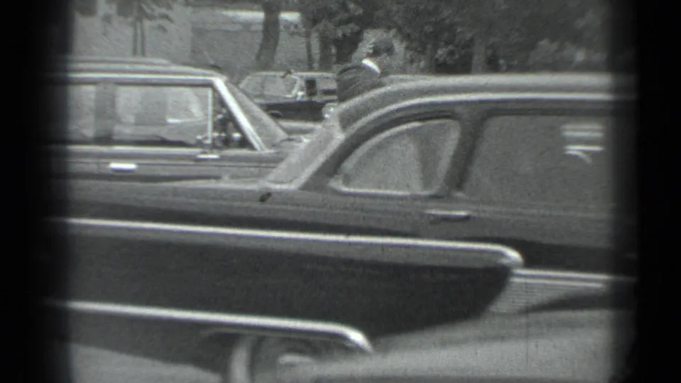 1983 Moscow street view with overlapping sedans and a suited figure partly visible near the parked vehicles.