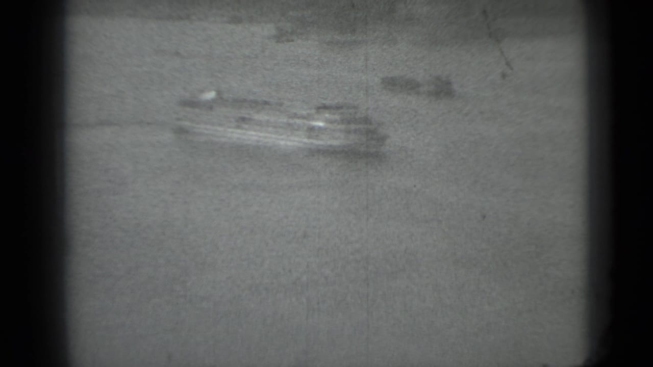 Distant multi-deck ferry on a wide Moscow river, filmed in soft black-and-white 8mm in 1983.