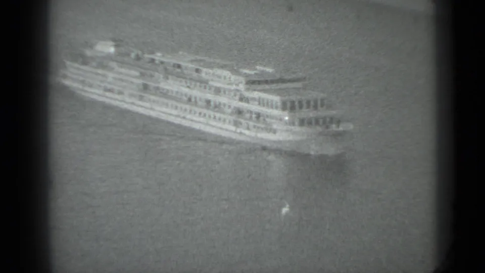A distant passenger ship moves across water in the supplied 1983 Moscow 8mm footage, with soft focus and visible frame borders.