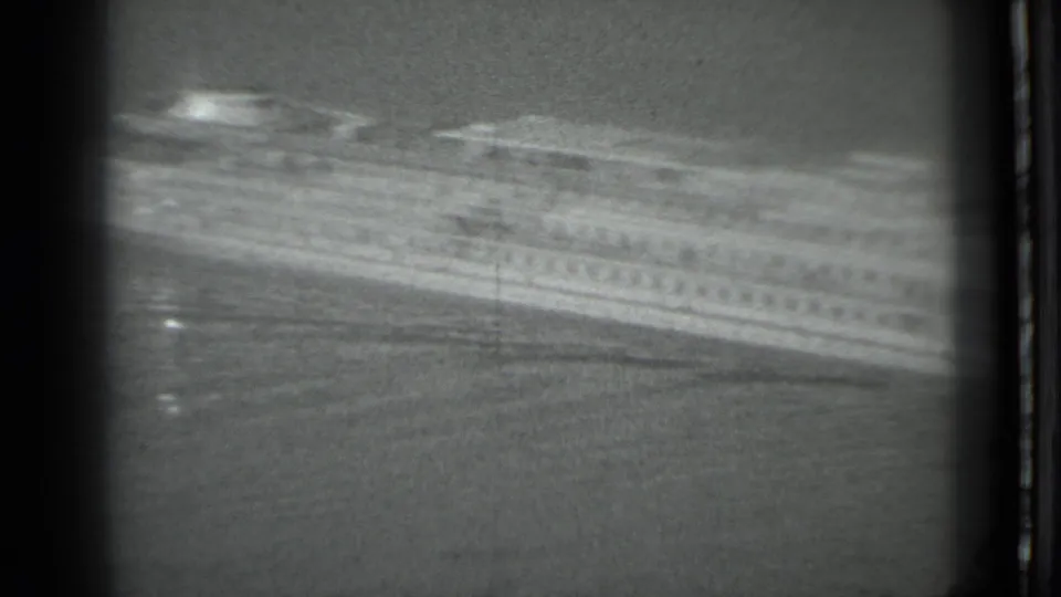 The passenger ship fills more of the 8mm frame, appearing blurred as it passes across calm water in the 1983 Moscow clip.
