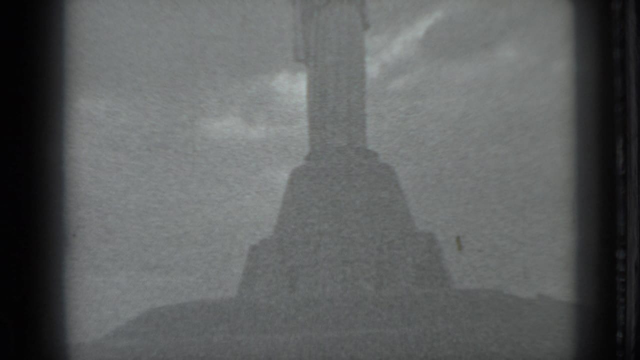 1983 Moscow 8mm frame showing a large historic or religious monument rising above a grassy hill under open sky.