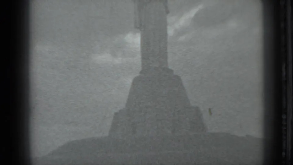 1983 Moscow 8mm frame showing a large historic or religious monument rising above a grassy hill under open sky.