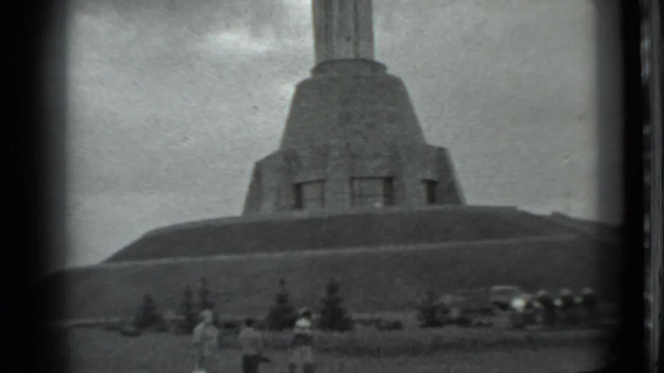 1983 Moscow footage shows visitors near small trees below the broad base of a large monument.