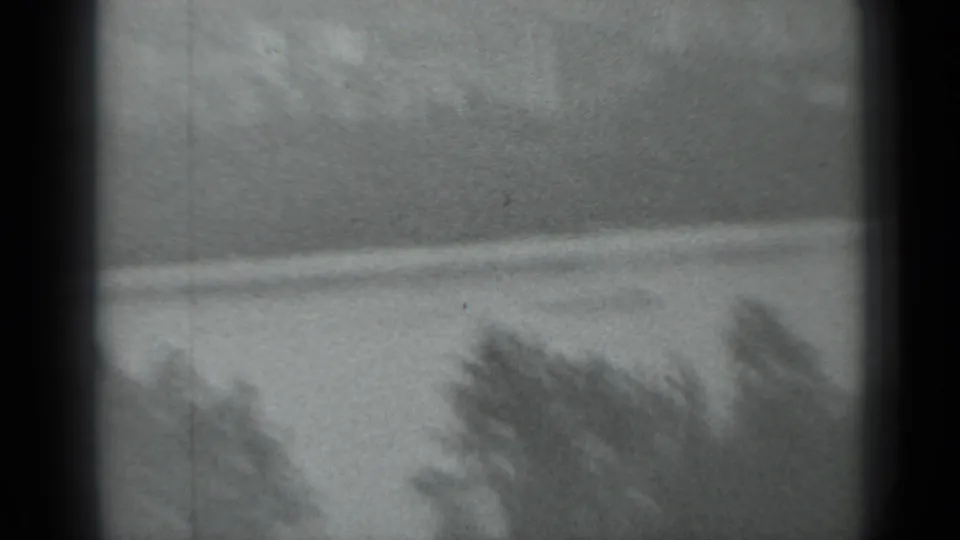 Soft, grainy 1983 Moscow frame showing water and a distant bank, partly obscured by small-gauge film borders.