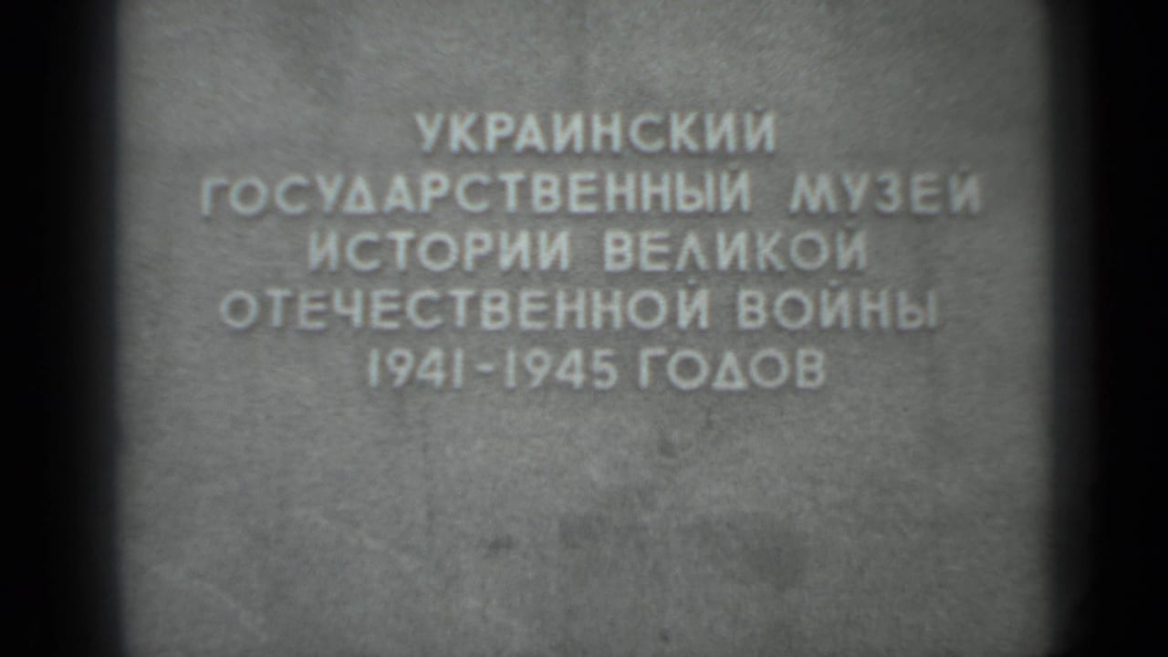 Repeated Cyrillic inscription on stone with visible film gate shadowing at the sides.