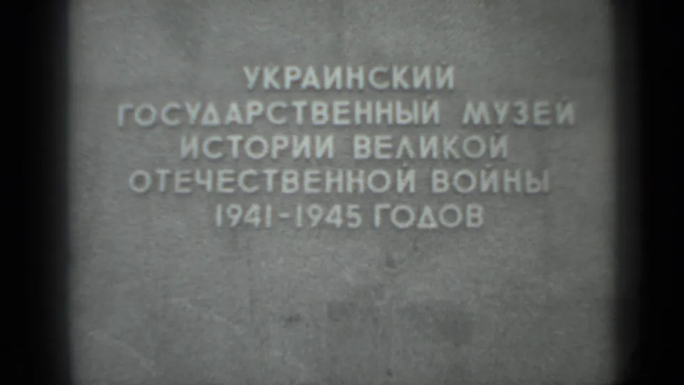 Soft, grainy 8mm view of the same Cyrillic museum inscription, with the 1941-1945 dates visible near the lower line.