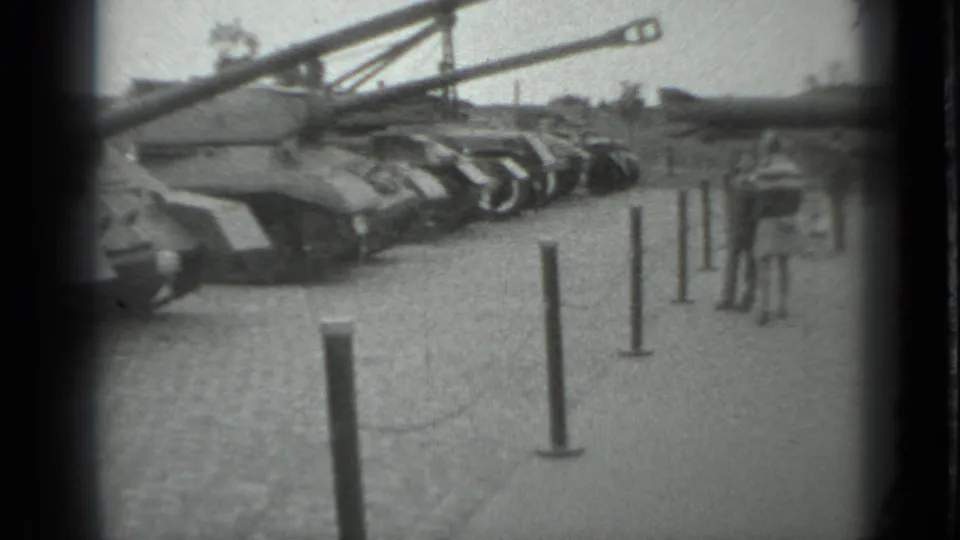 1983 Moscow 8mm frame showing tanks lined up behind metal stanchions in an outdoor public viewing area.