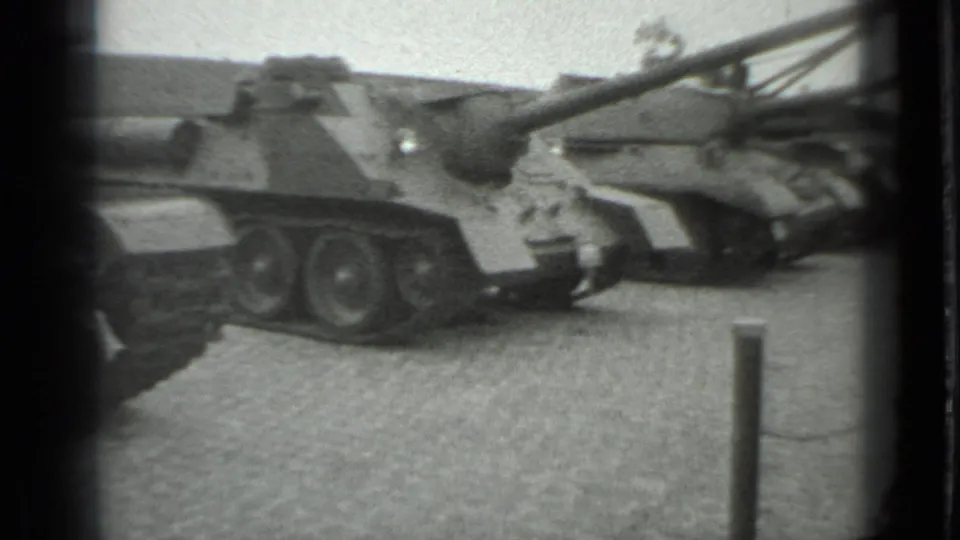 1983 Moscow frame showing a close side view of an armored tank near a low stanchion barrier.