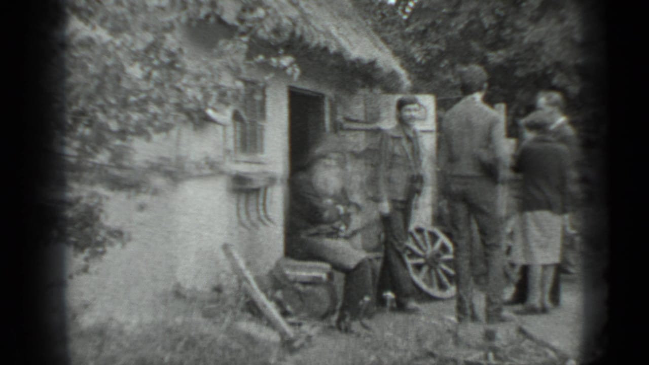 Adults stand beside a rustic cottage doorway in the Moscow 1983 footage, near a seated man and a wagon wheel display.