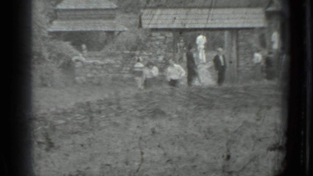 A distant group of pedestrians appears beside a stone wall and older village house, matching the supplied Moscow, Russia 1983 context.