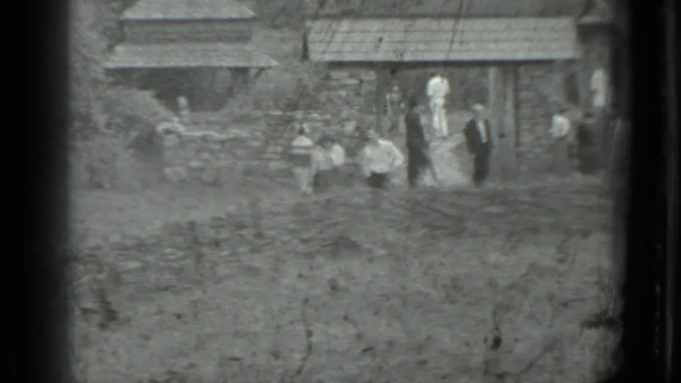 A distant group of pedestrians appears beside a stone wall and older village house, matching the supplied Moscow, Russia 1983 context.