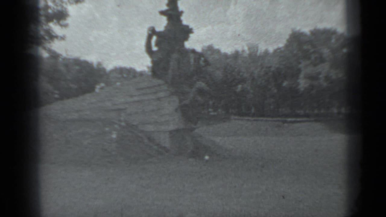 A wide 1983 Moscow frame shows a large outdoor sculptural monument rising above lawn, paths, and surrounding trees.